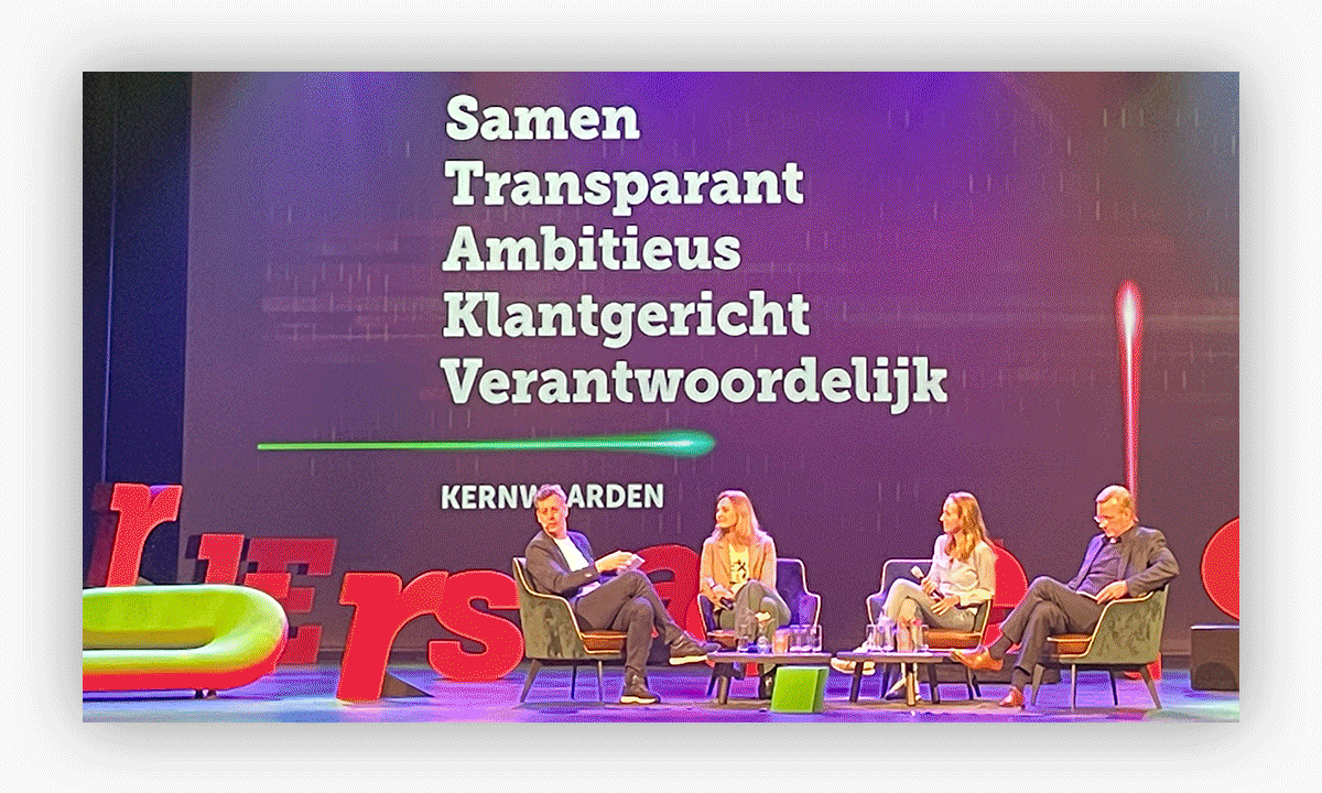Medewerkersevent in het theater om het nieuwe employer brand te presenteren. Je ziet medewerkers op het podium zitten en als een 'late night'. show de nieuwe kernwaarden presenteren