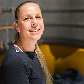 Portret van een glimlachende vrouw met een lange blonde paardenstaart