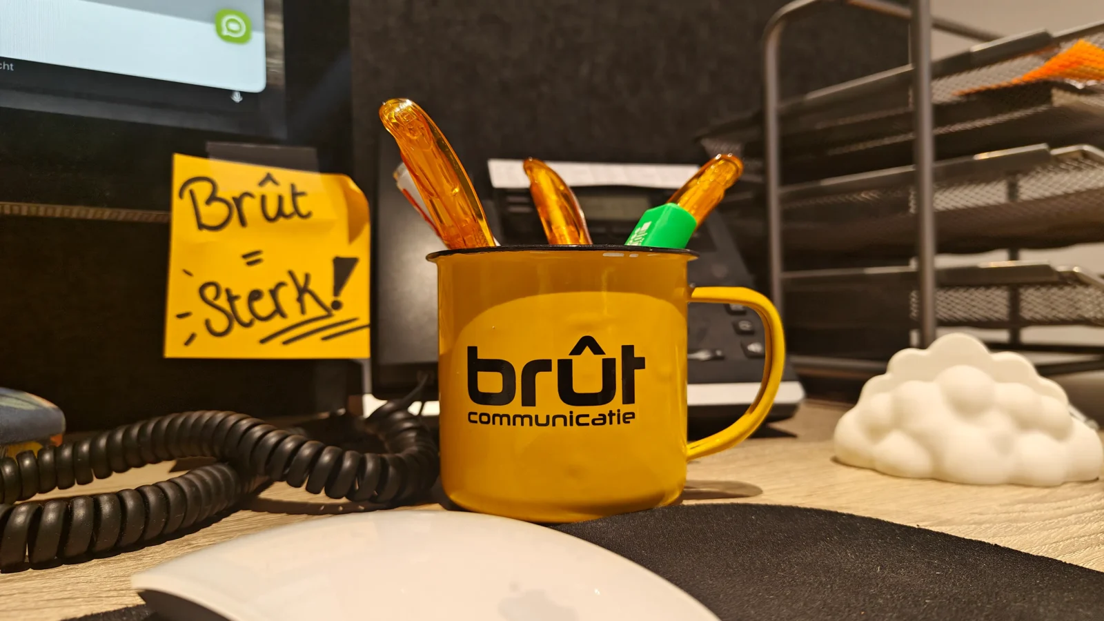 Bureaumok van Brût met pennen en een briefje met de tekst ‘Brût = Sterk!’
