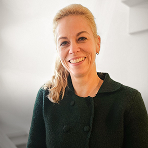 Portret van een glimlachende blonde vrouw in een donkere jas