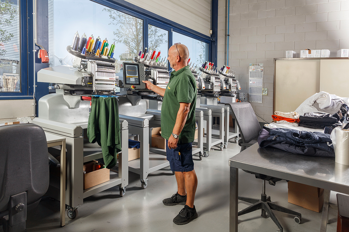 Man aan het werk met een bedrukking machine voor kleding